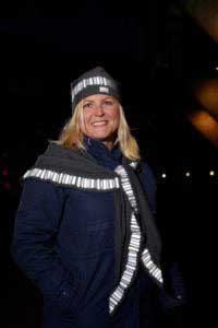 Kvinna i sjal med reflex i mönstret norrsken, I melerad grå färg. Bomullsmössa, Antracit med mönstret norrsken i reflex