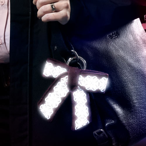 reflexrosett, bag charm, på väska som dekoration och smycke. smart in the dark.