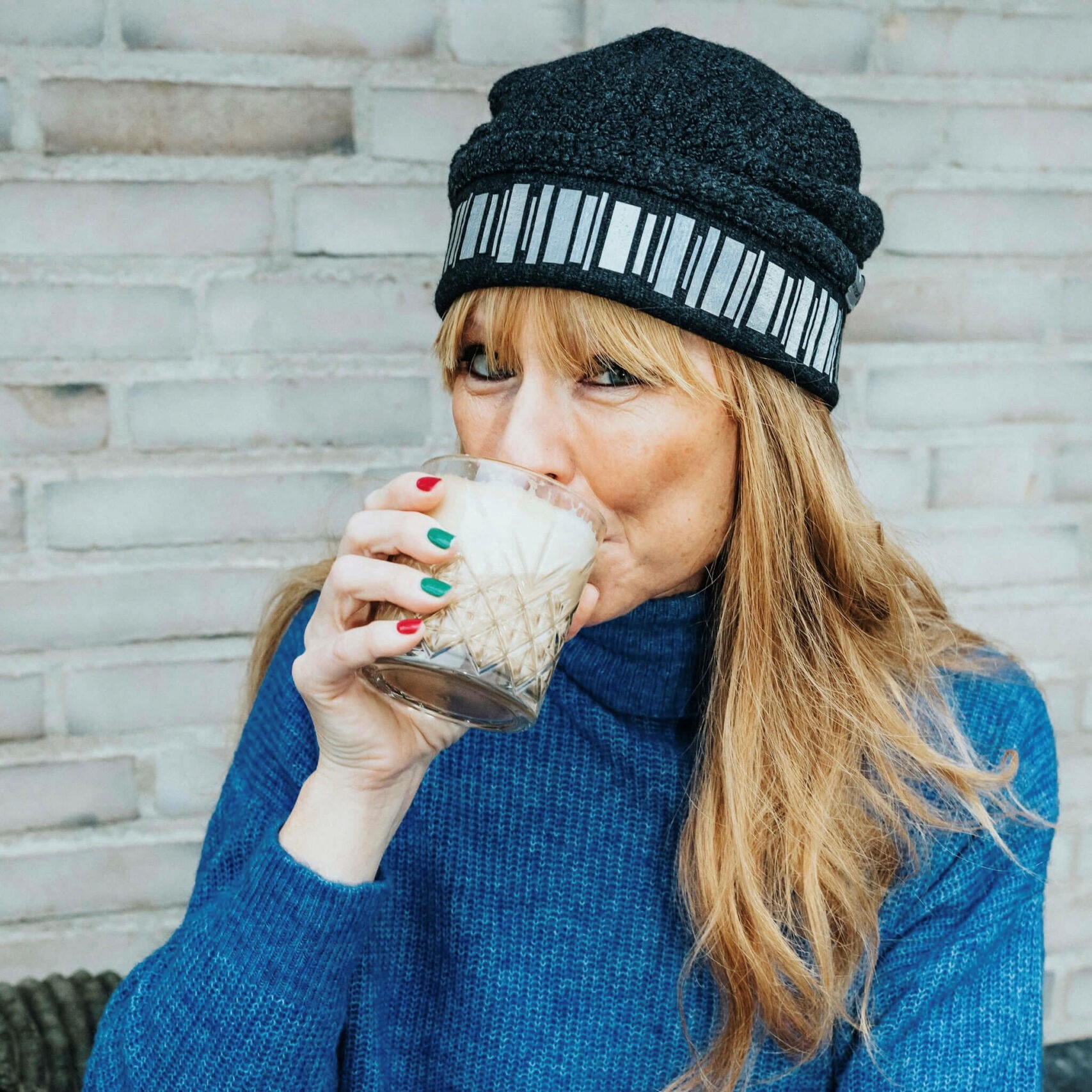 Frida Zetterström i en klassisk ullmössa i ull och kashmir. Reflex runt hela mössan i det popelära motovet Norrsken. Mössan kommer från Smart in the dark